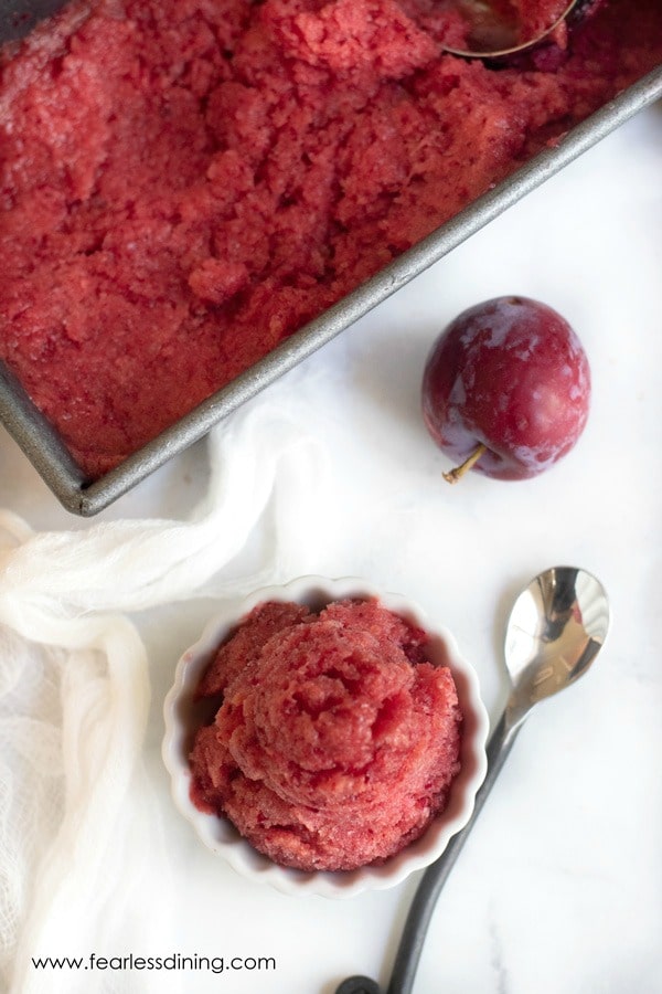 The top view of a bowl of plum sorbet and the container.