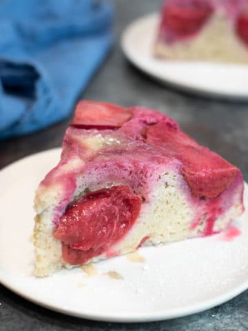 a slice of plum upside down cake on a small white plate