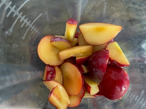 The chopped plums in a blender.