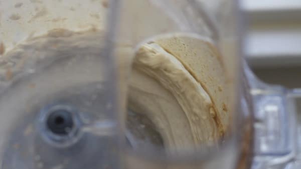 Blending cream cheese in a food processor.