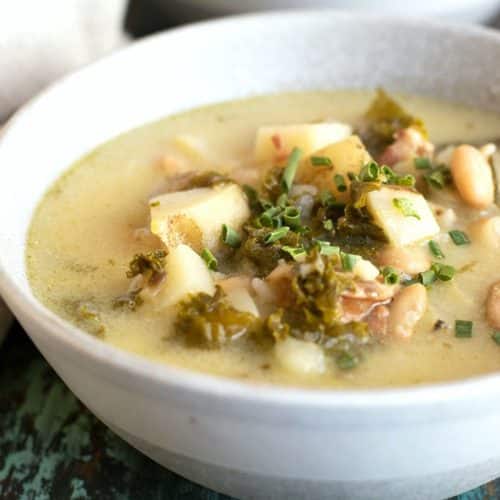 Two bowls of slow cooker zuppa potato kale soup on a table.