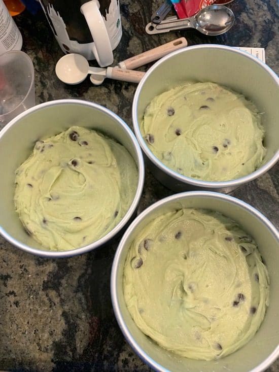 Mint chip cake batter in 3 round cake pans.