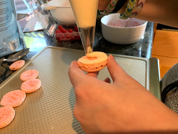 Frosting the middle of macarons.