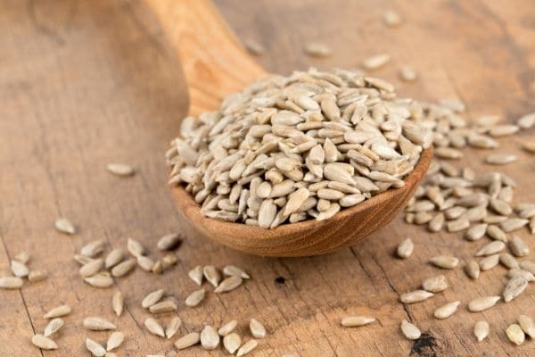 Raw sesame seeds in a wooden spoon.