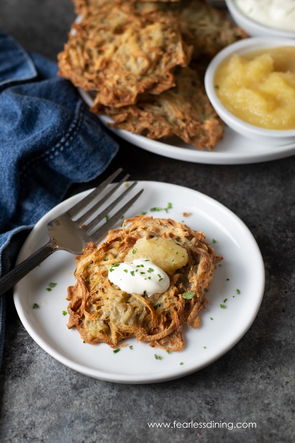 A latke topped with apple sauce and sour cream.