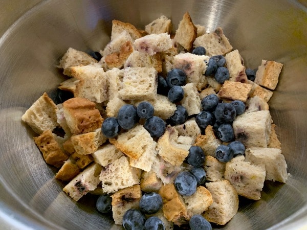 Cubed bread and blueberries in a bowl.