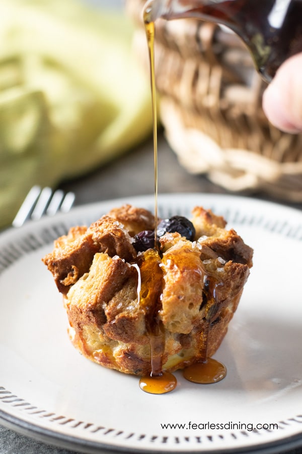drizzling maple syrup over the gluten free blueberry French toast muffin