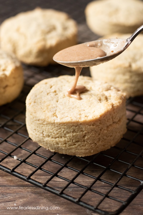 drizzling pumpkin spice icing over the gluten free scones
