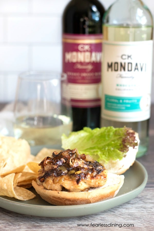 Ground chicken burger with bottles of wine.