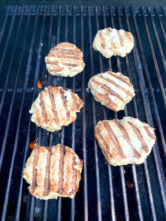 Ground chicken burgers cooking on the grill.