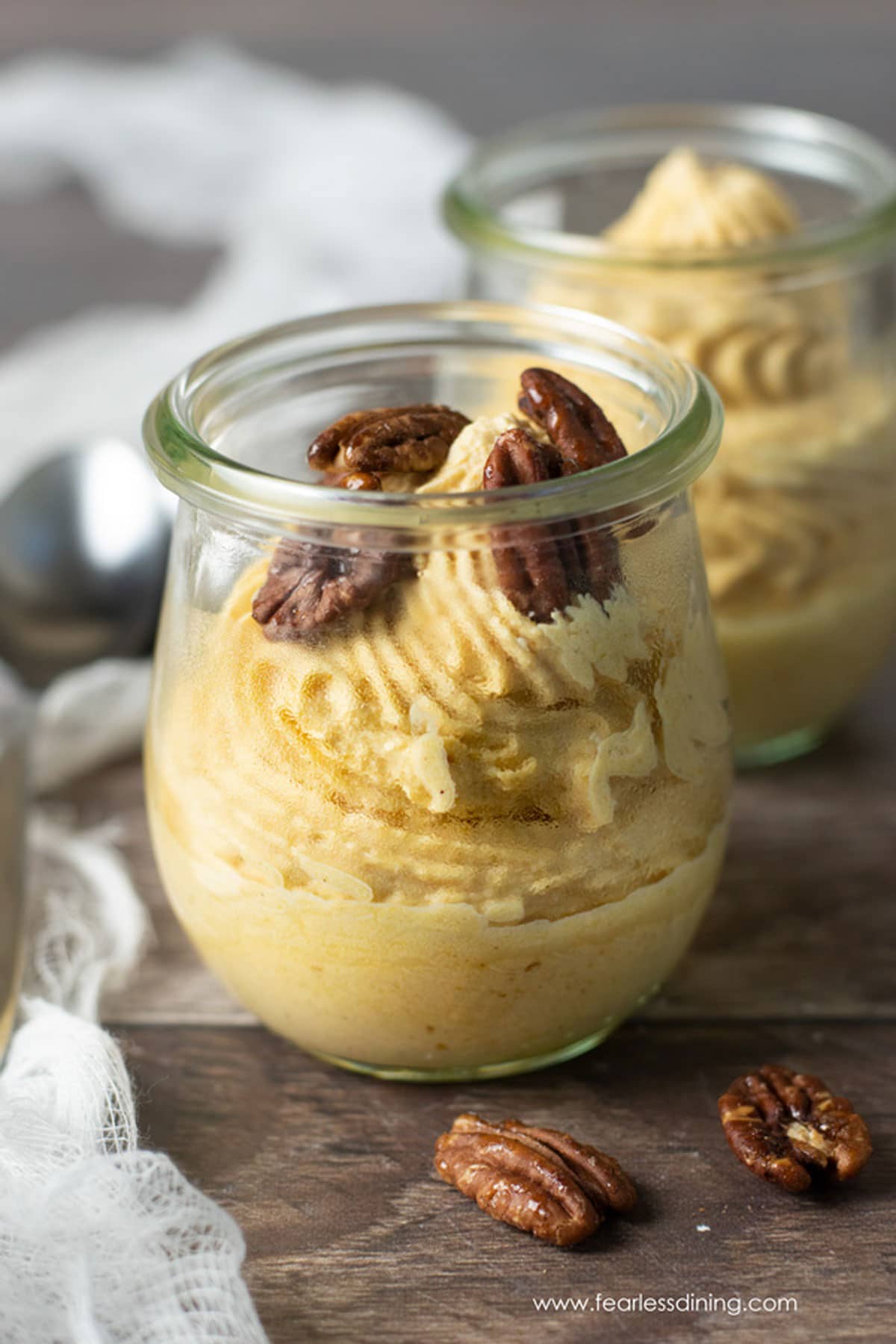 Jars of pumpkin mousse topped with candied pecans.