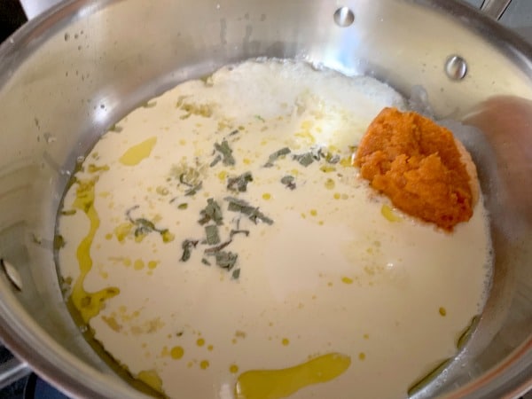 Pumpkin alfredo ingredients in a skillet.