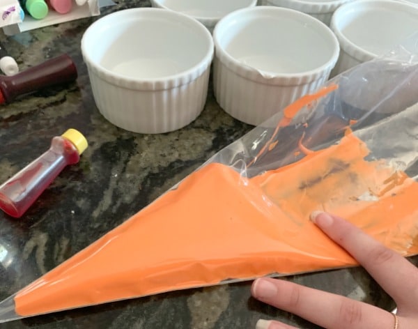 Orange royal icing in a piping bag.
