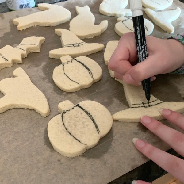 Tracing designs on the halloween sugar cookies.