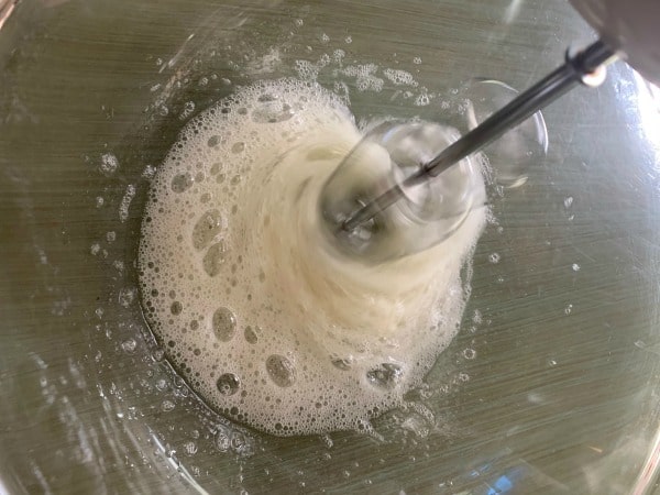 Whipping the egg whites with an electric mixer.