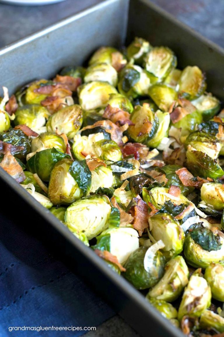 A 9x13 metal baking pan filled with roasted Brussels sprouts and bacon.