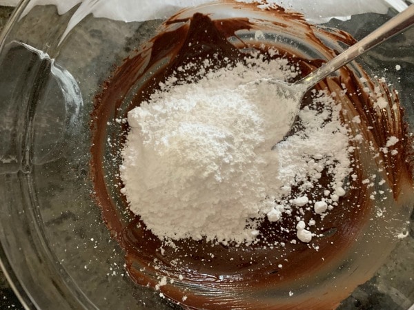 adding powdered sugar to the melted chocolate