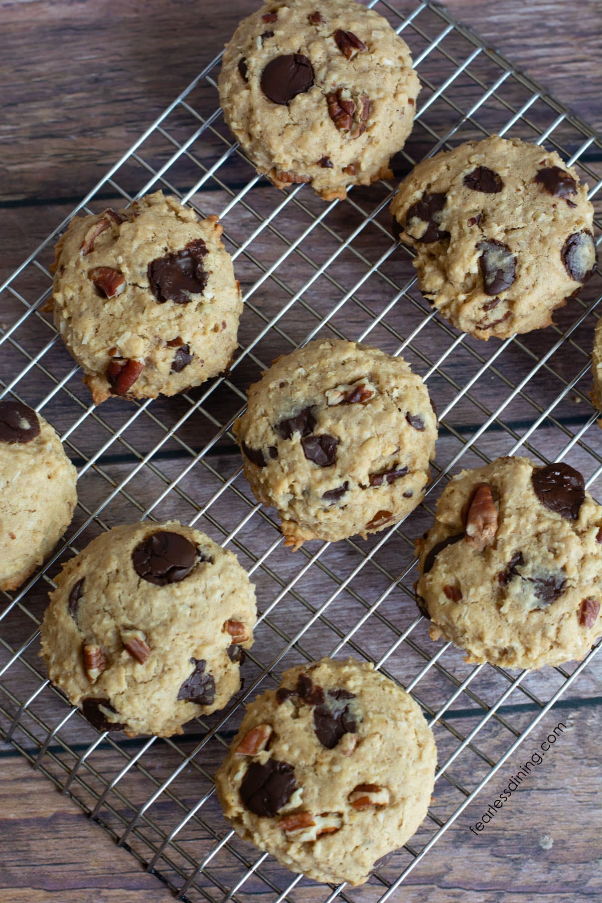 A cooling rack full of baked gluten-free cowboy cookies.