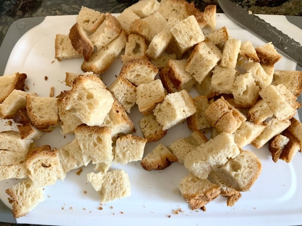 The cubes of bread on a cutting board.