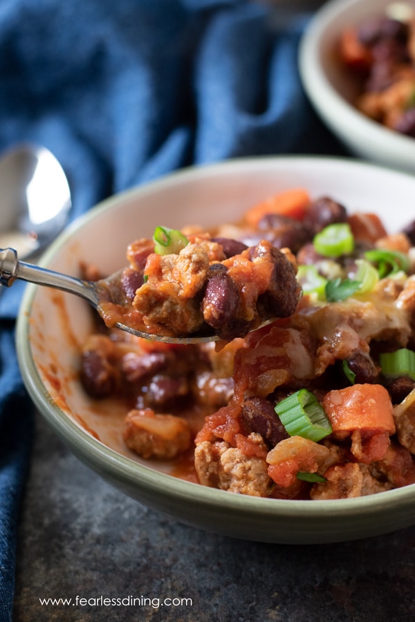 A spoon full of ground pork chili.