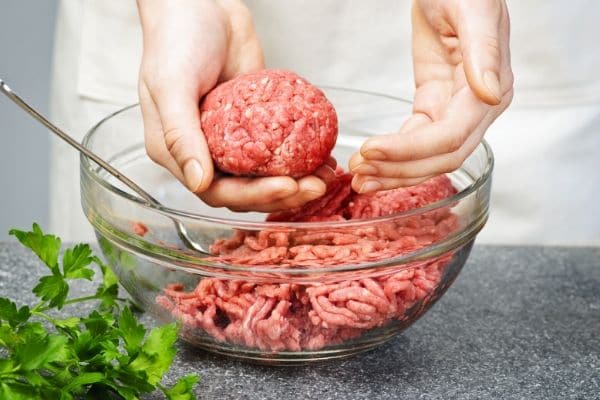 hands making a meatball with ground pork