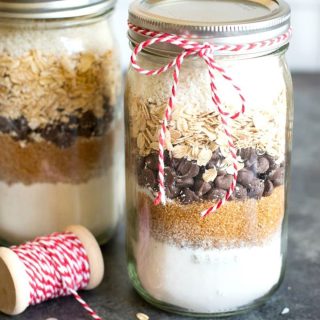 Mason jars filled with layers of ingredients for cookie mix.