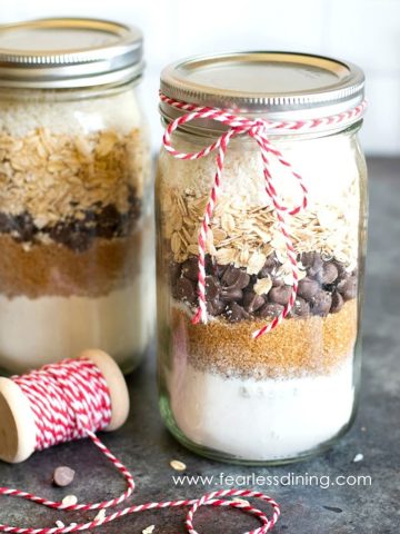 Mason jars filled with layers of ingredients for cookie mix.