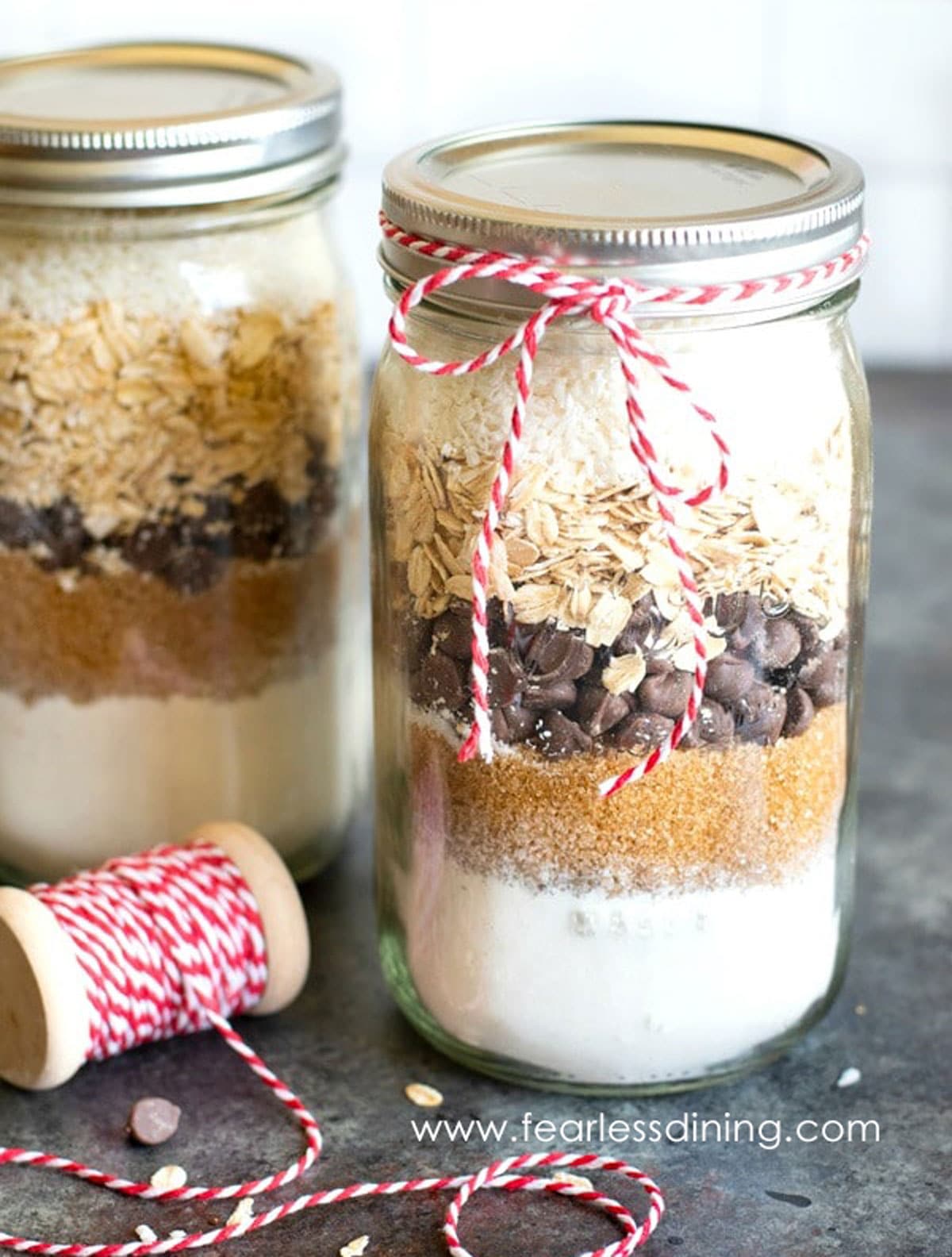 Mason jars filled with layers of ingredients for cookie mix.