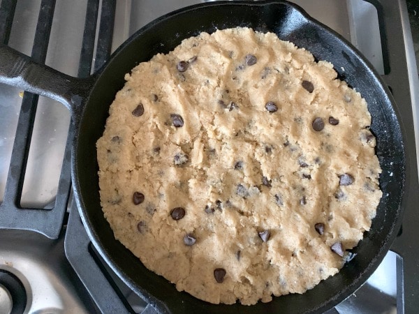 The cookie dough in a cast-iron skillet.