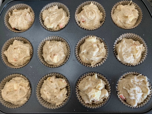 apple muffin batter in a muffin tin ready to bake