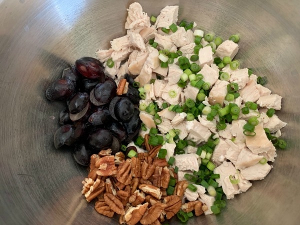 A mixing bowl with the curry chicken salad ingredients.