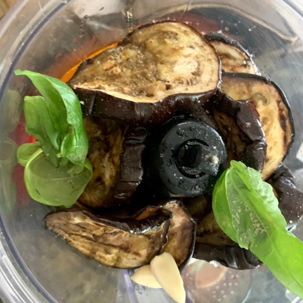 Roasted eggplants and red peppers with basil and garlic in a food processor.