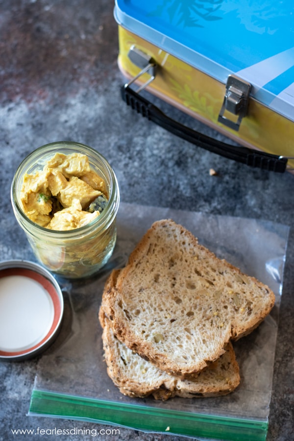 Chicken curry salad in a jar with sliced bread.