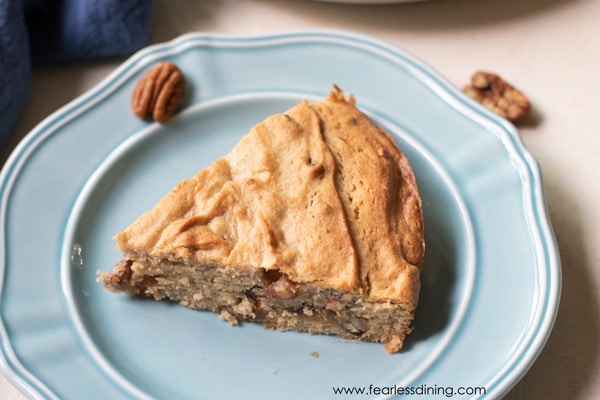 A slice of gluten free date nut cake on a light blue colored plate.