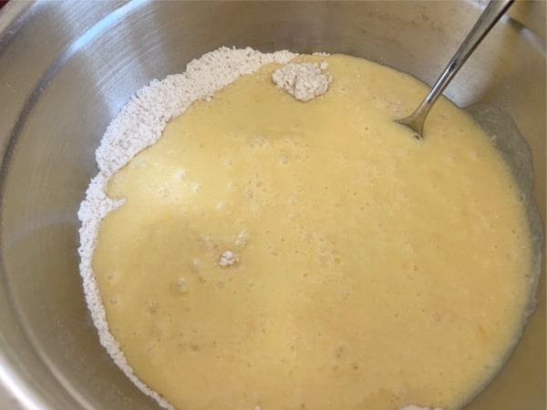 The wet and dry ingredients in a bowl about to be mixed.