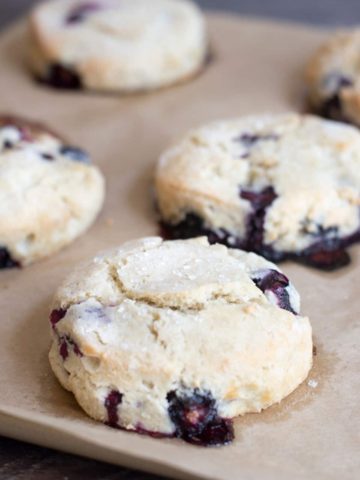 Baked blueberry scones on a baking sheet.