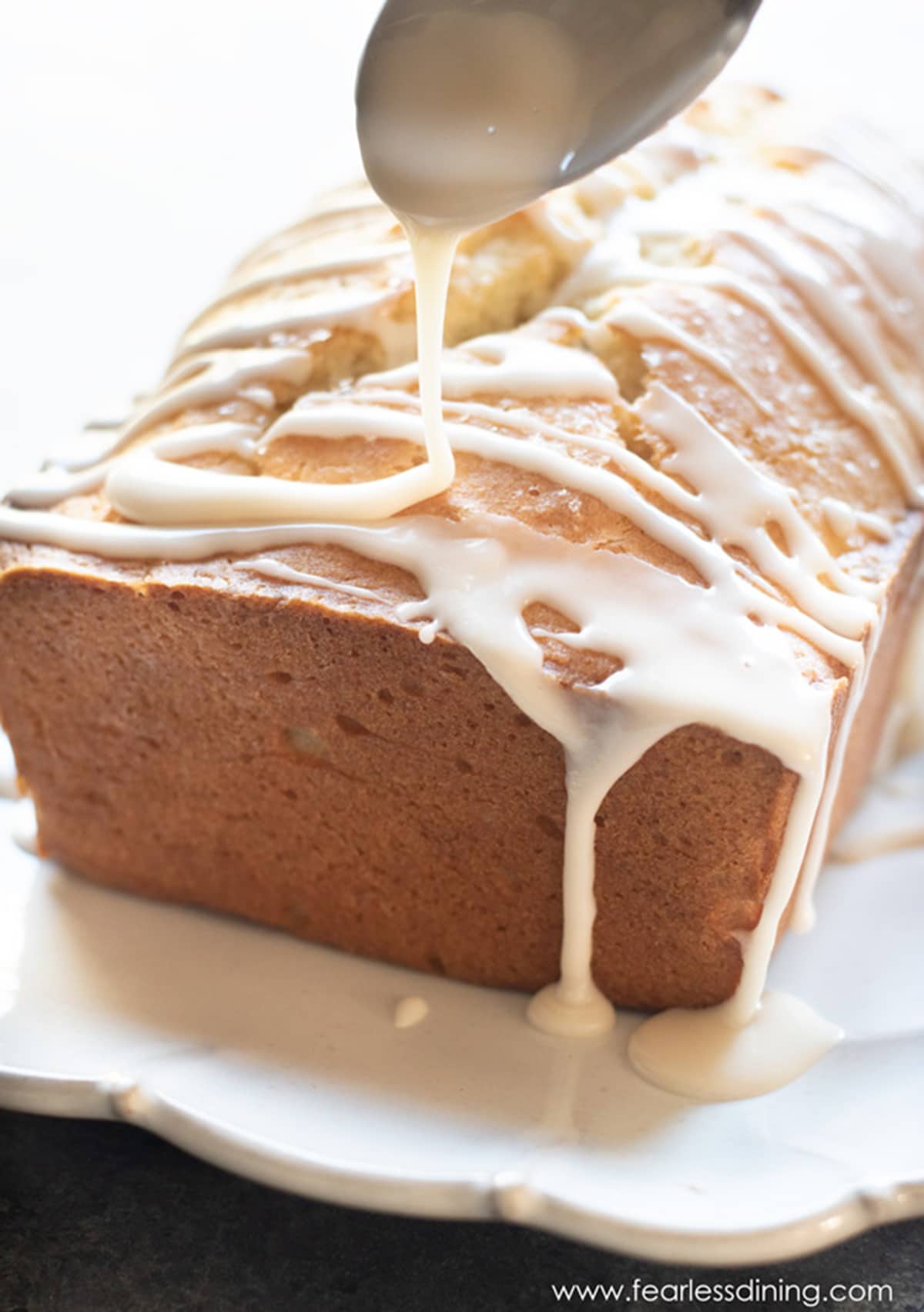 Drizzling icing over a lemon pound cake.