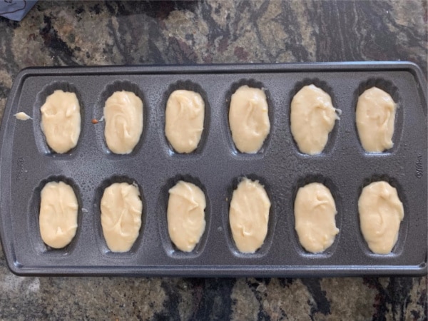 Madeleine batter in a madeleine pan ready to bake.