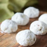 Six Russin a tea cookies on a wooden serving dish.