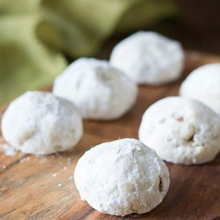 Six Russin a tea cookies on a wooden serving dish.