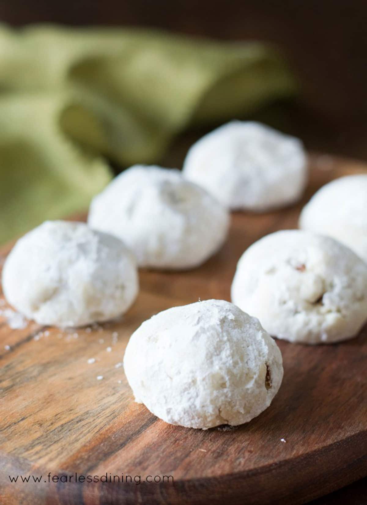 Six Russin a tea cookies on a wooden serving dish.