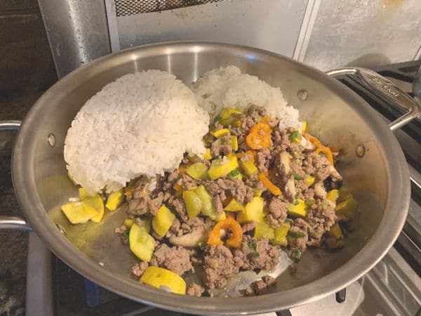 Cold white rice added to the cooking meat.