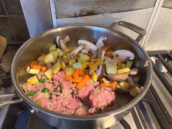 All of the uncooked ingredients in a pan on the stove ready to cook.