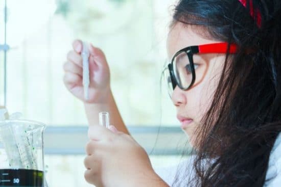 A child doing a science experiment with a test tube.