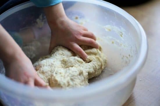 kid's hands mixing dough in a large bowl