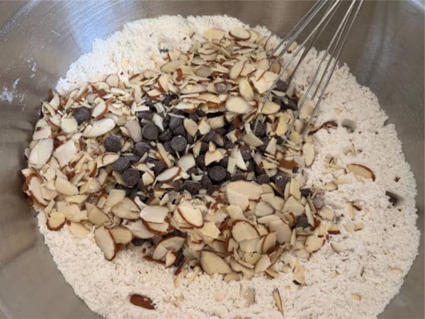 All of the mandelbrot dry ingredients in a bowl including chocolate chips and almonds.