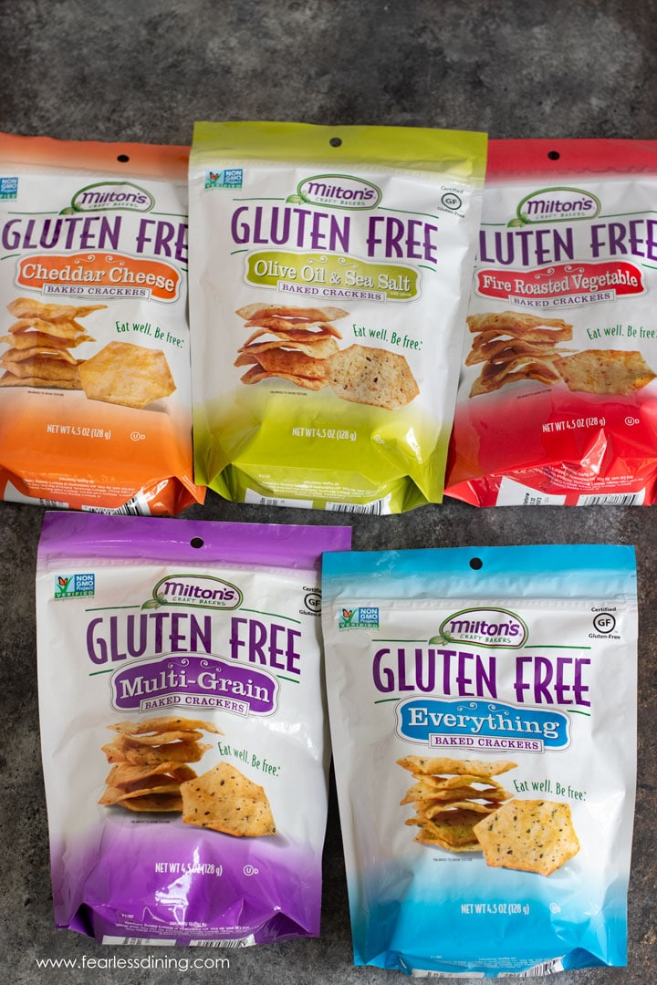 Six bags of Milton's gluten free crackers, one bag in each flavor variety