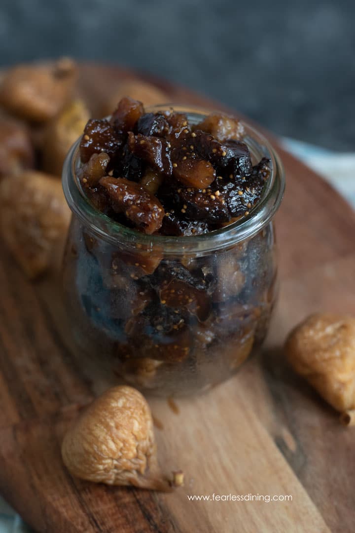 A small mason jar filled with a dried fig and walnut chutney.