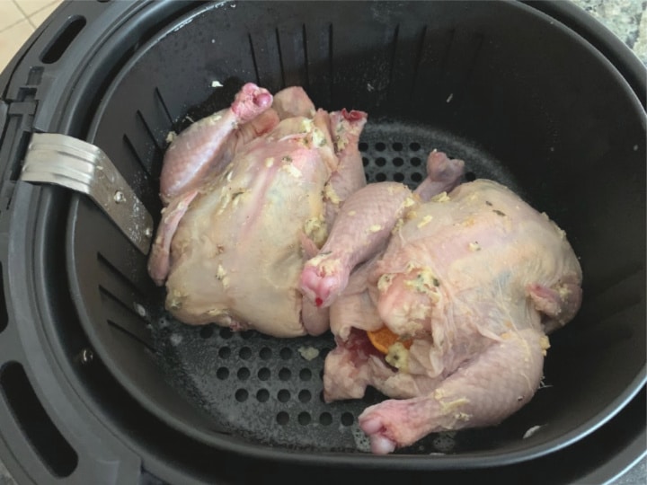 The Cornish hens in the air fryer ready to cook.