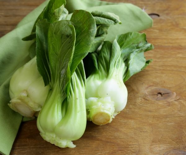 Washed bok choy on a cutting board.